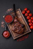 Grilled wagyu beef tomahawk steak with salt, spices and herbs photo