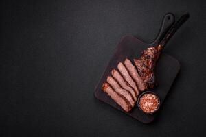 Grilled wagyu beef tomahawk steak with salt, spices and herbs photo