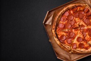 Pepperoni pizza with sausage, mozzarella cheese, tomatoes, salt and spices photo