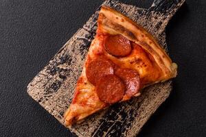 Pepperoni pizza with sausage, mozzarella cheese, tomatoes, salt and spices photo