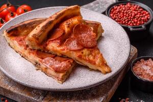 Pepperoni pizza with sausage, mozzarella cheese, tomatoes, salt and spices photo