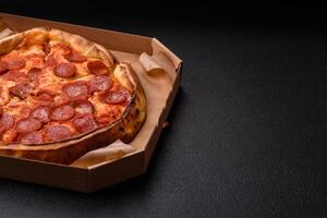 Pepperoni pizza with sausage, mozzarella cheese, tomatoes, salt and spices photo