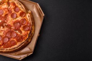 Pepperoni pizza with sausage, mozzarella cheese, tomatoes, salt and spices photo