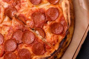 Pepperoni pizza with sausage, mozzarella cheese, tomatoes, salt and spices photo
