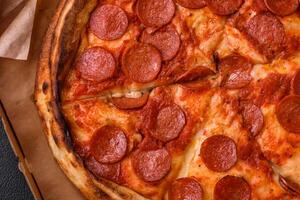 Pepperoni pizza with sausage, mozzarella cheese, tomatoes, salt and spices photo