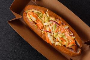 Hotdog with grilled sausage with cabbage, carrots and onions photo