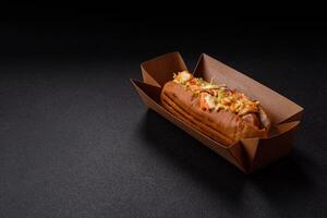 Hotdog with grilled sausage with cabbage, carrots and onions photo