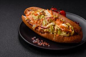 Hotdog with grilled sausage with cabbage, carrots and onions photo