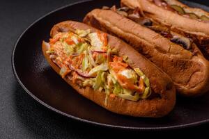 Hotdog with grilled sausage with cabbage, carrots and onions photo