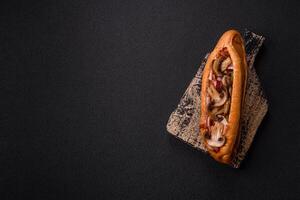 Hotdog with grilled sausage with bacon and mushrooms photo