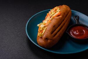 Hotdog with grilled sausage with cabbage, carrots and onions photo