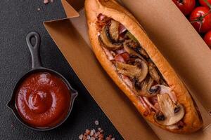 Hotdog with grilled sausage with bacon and mushrooms photo