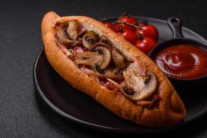 Hotdog with grilled sausage with bacon and mushrooms photo