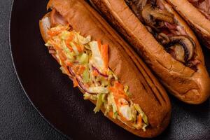 Hotdog with grilled sausage with cabbage, carrots and onions photo