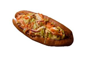 Hotdog with grilled sausage with cabbage, carrots and onions photo