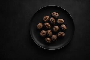 Walnuts resting on a dark plate, creating a striking contrast photo