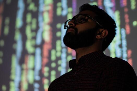 Indian programmer analyzing code projected on wall in office photo