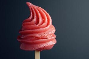 Vegan strawberry ice cream melting on wooden stick on dark background photo