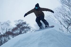 Snowboarder jumping high on snowy slope in winter forest photo