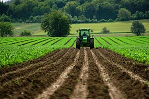 Farmer cultivating field with tractor in beautiful countryside photo