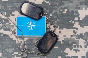 US flag patch with dog tag on multicam camouflage uniform photo