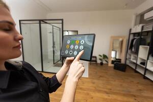 Digital composite of Hands using smart home application on tablet PC photo