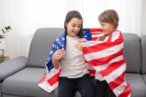 cheerful adorable kids standing under american flag and looking at camera photo