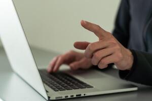 Finger pointing to laptop screen with important technology news. Businessman pressing virtual button on display. photo