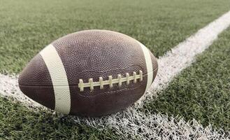 American football resting on a first down line during an American football game. The ball is ready to be snapped to start a new play. Lots of copy space photo