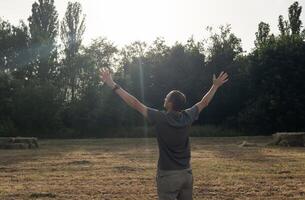 A Man Looking At Sky With Arms Wide Open photo