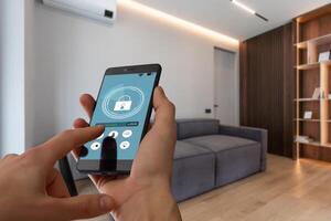 Young woman holding smart phone with launched security application at home. Concept of controlling and managing home security from a mobile device photo