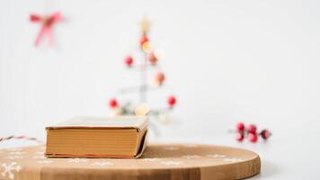 Book on Wooden Cutting Board with Christmas Tree in Background photo
