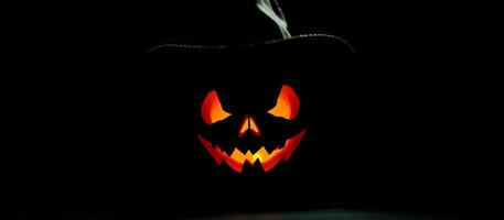 Glowing Jack-o'-Lantern with Hat on Black Background photo