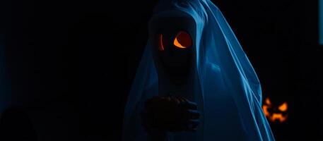 ghostly figure holds a small pumpkin the dark photo