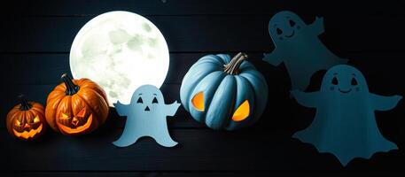 blue pumpkin with carved eyes sits among friendly ghosts under a full moon. photo
