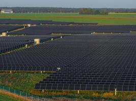 Expansive Solar Panel Farm in Lithuania with Lush Green Fields photo
