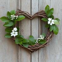 heart shaped wreath with green leaves and white flowers on rustic wooden background photo