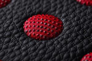 close up of a red strawberry on black leather photo