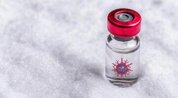 covid 19 vaccine vial on snowy background photo