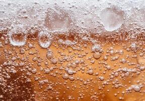 Closeup of fizzing and bubbling beer or soda photo
