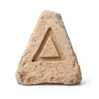 Carved stone triangle symbol on white background photo