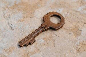 Rusty old key on a weathered surface photo