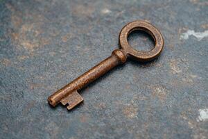 Rusty old key on a weathered surface photo