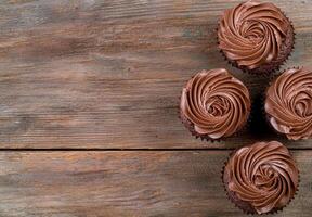 Delicious chocolate cupcakes with swirled frosting on a rustic wooden background photo