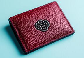 Closeup of a red leather wallet with a stylized logo photo