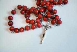 Red rosary on plain background photo
