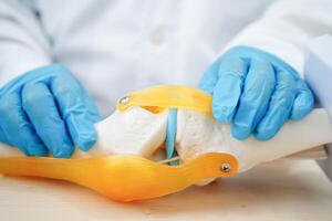Knee osteoarthritis, Doctor showing model knee joint orthopedic. photo