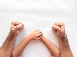Parent and child fists together on white background symbolizing unity and support photo