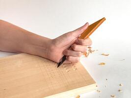 Hand engraving wood with chisel, artistic craftsmanship in action photo
