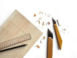 Wood carving tools and shavings on white background photo